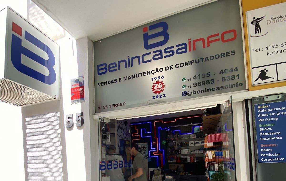 Fachada da Benincasa Info no térreo do Centro Comercial Alphaville, com o logo, o número 55 e a porta de vidro mostrando o neon da loja